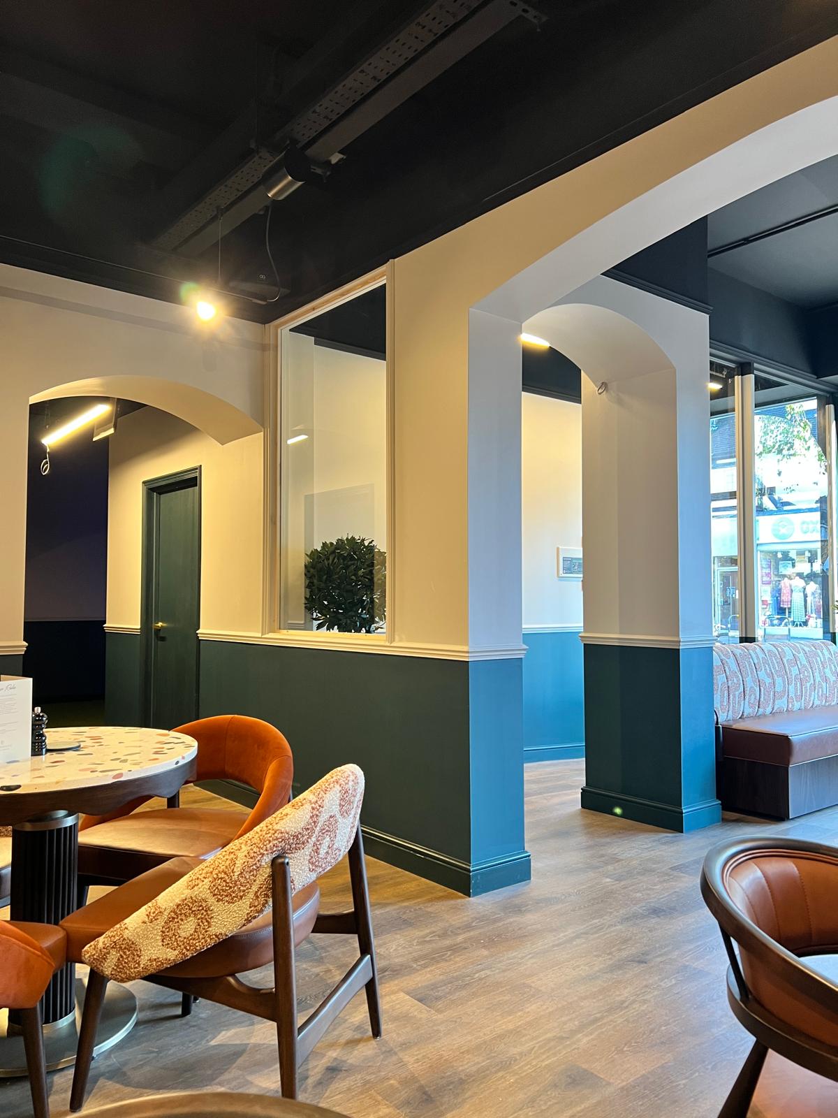 Panelled dining area with arched openings and glazed screens